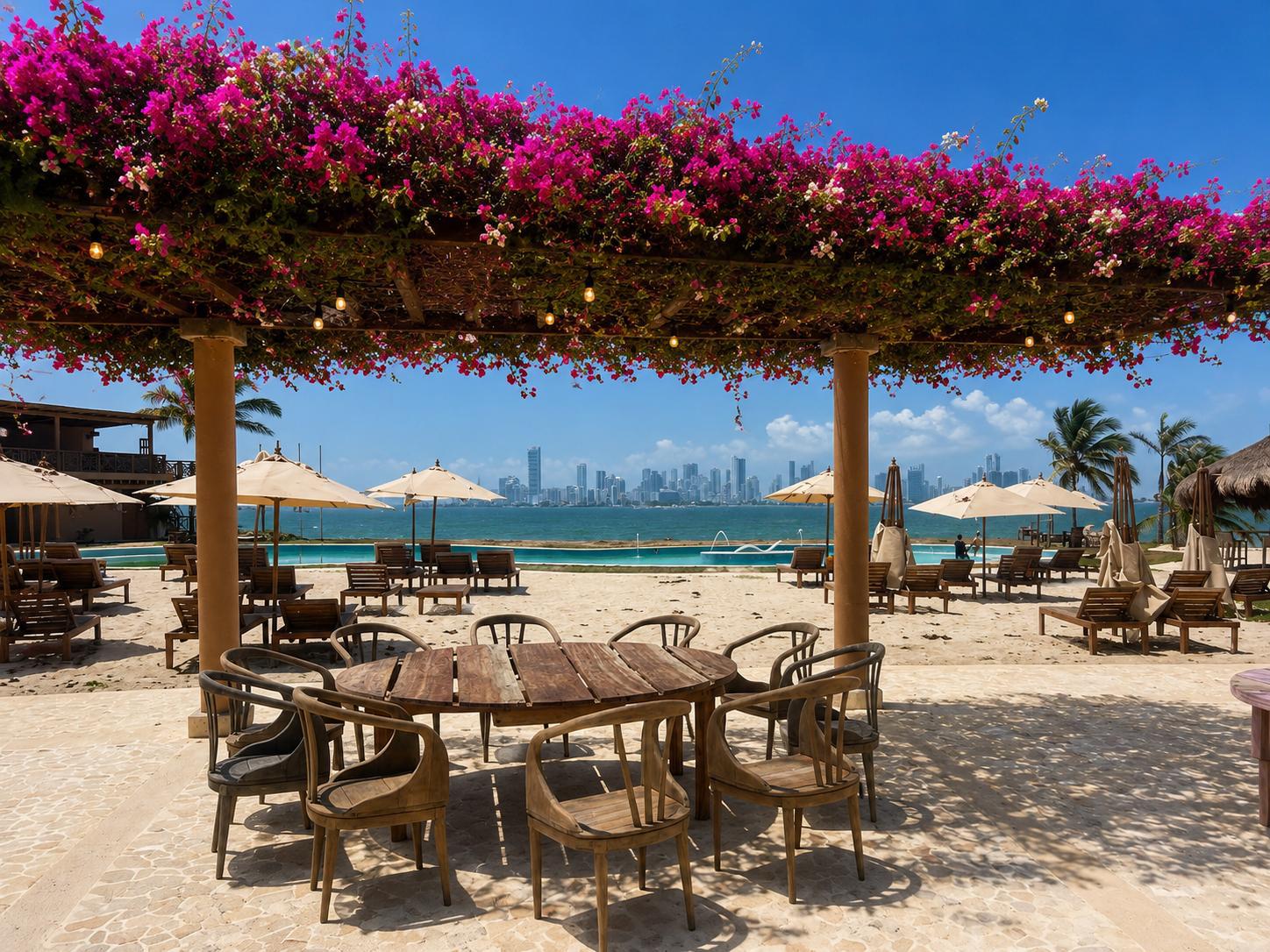 Beach club under a bougainvillea pergola — white sand, umbrellas, pool and the Cartagena skyline across the water